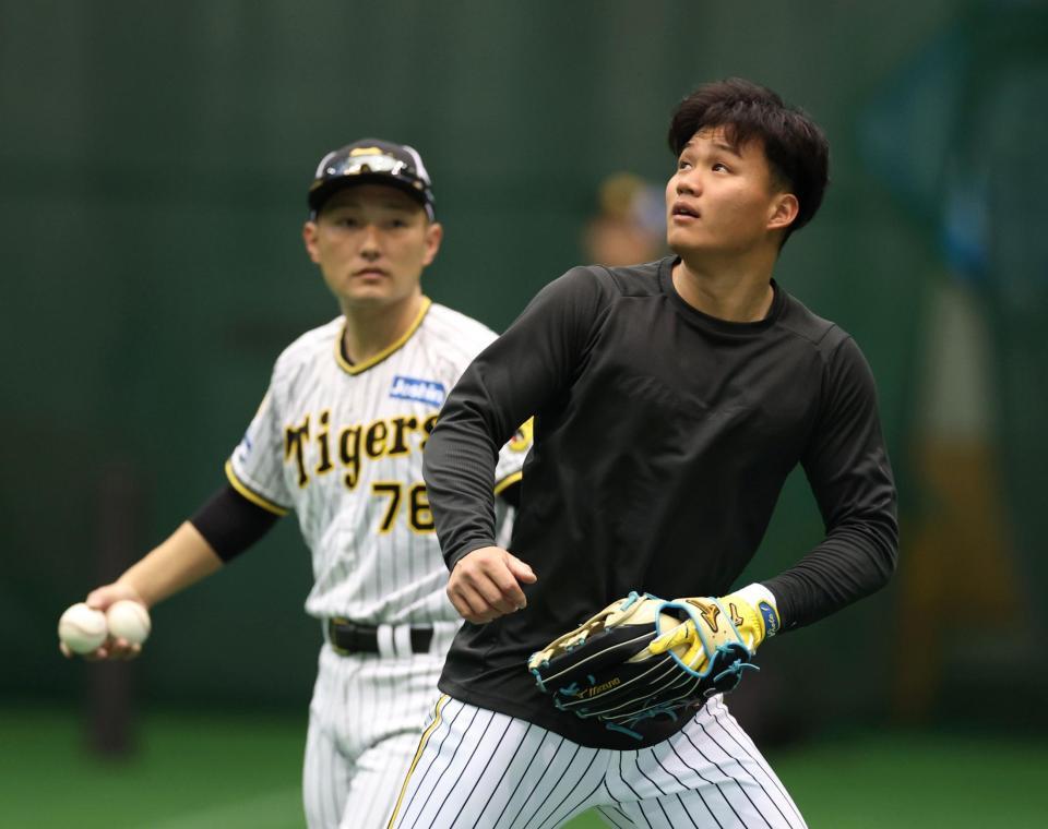 　工藤外野守備走塁コーチ（後方）の指導を受けながら練習する森下（撮影・中田匡峻）