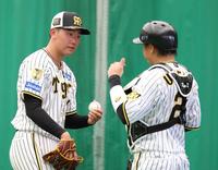 　ブルペンで梅野（右）と話す門別