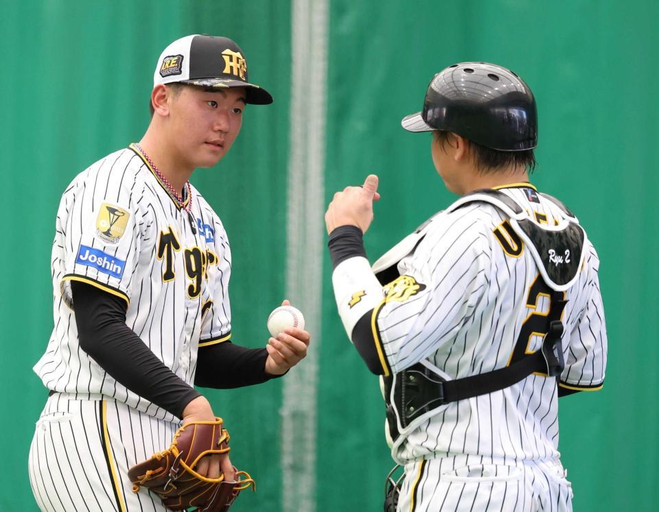 　ブルペンで梅野（右）と話す門別
