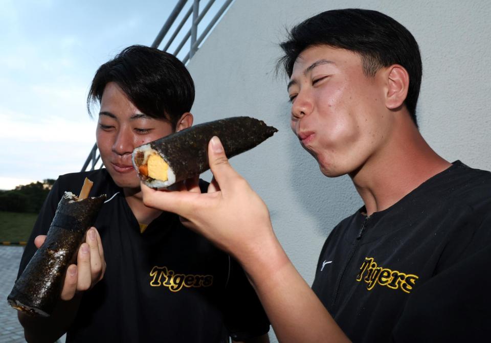 　恵方巻きを丸かぶりする下村（左）と山田（撮影・山口登）