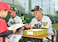 　野球教室を終えた子どもたちにサイン色紙をプレゼントする門別（撮影・立川洋一郎）