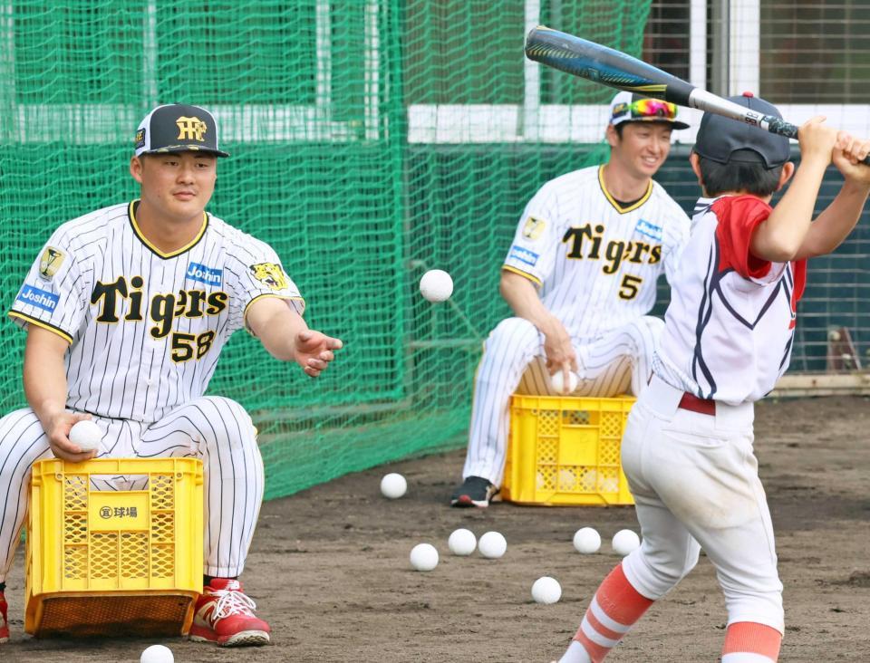 　野球教室で子どもにトスを上げる