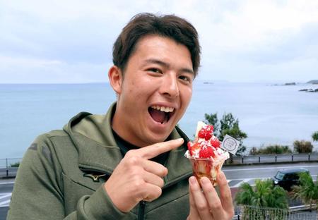 　宜野座村特産のいちごを使ったパフェを手に笑顔を見せる