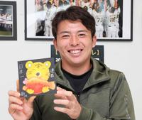 　完成した絵を手にして笑顔を見せる