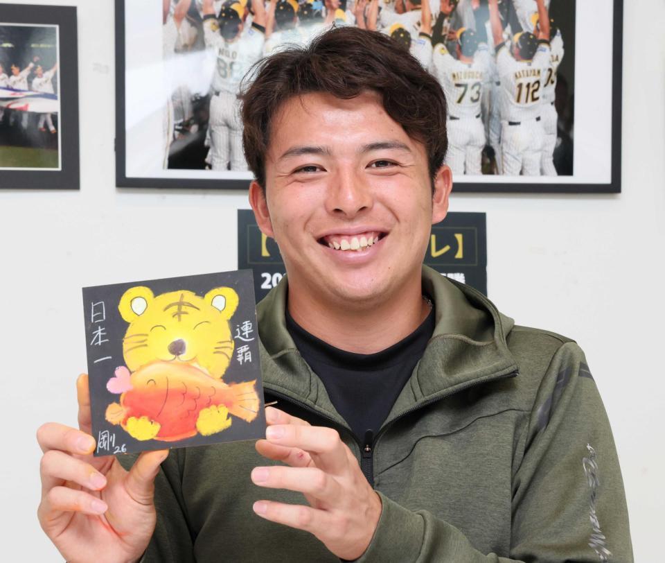 　完成した絵を手にして笑顔を見せる