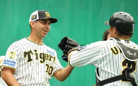 　ブルペンを終え梅野（右）とタッチを交わすゲラ