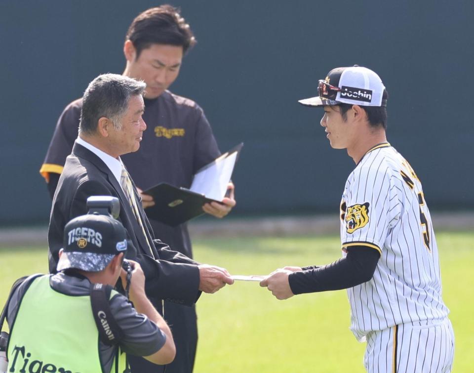 　陣中見舞いで、中野に目録を手渡す川藤ＯＢ会長（撮影・田中太一）