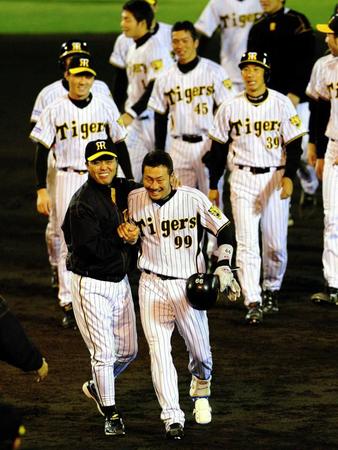 　延長十二回、代打の狩野は左線へサヨナラ安打を放ち、出迎える岡田監督とがっちり握手を交わす＝２００７年３月