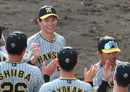 　９回裏に登板して最後を締めくくりナインと勝利のタッチを交わす湯浅（撮影・立川洋一郎）