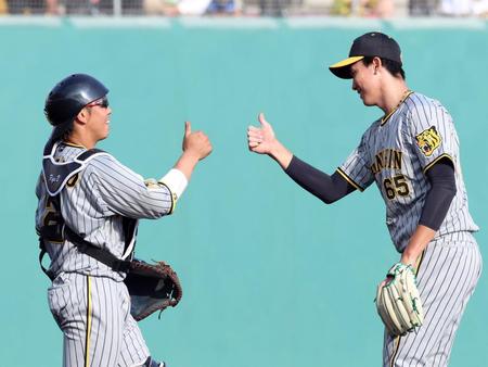 　試合を終え、梅野（左）とタッチする湯浅（撮影・山口登）