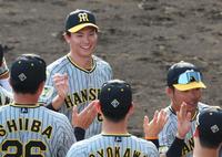 　９回裏に登板して最後を締めくくりナインと勝利のタッチを交わす湯浅（撮影・立川洋一郎）