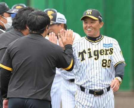 　キャンプを打ち上げ、スタッフとハイタッチを交わす岡田監督（撮影・伊藤笙子）