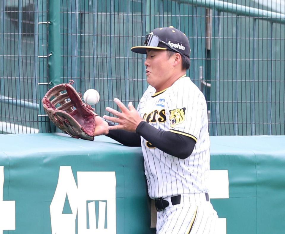 　シートノックでフェンスに当たった打球の処理にもたつく前川（撮影・中田匡峻）