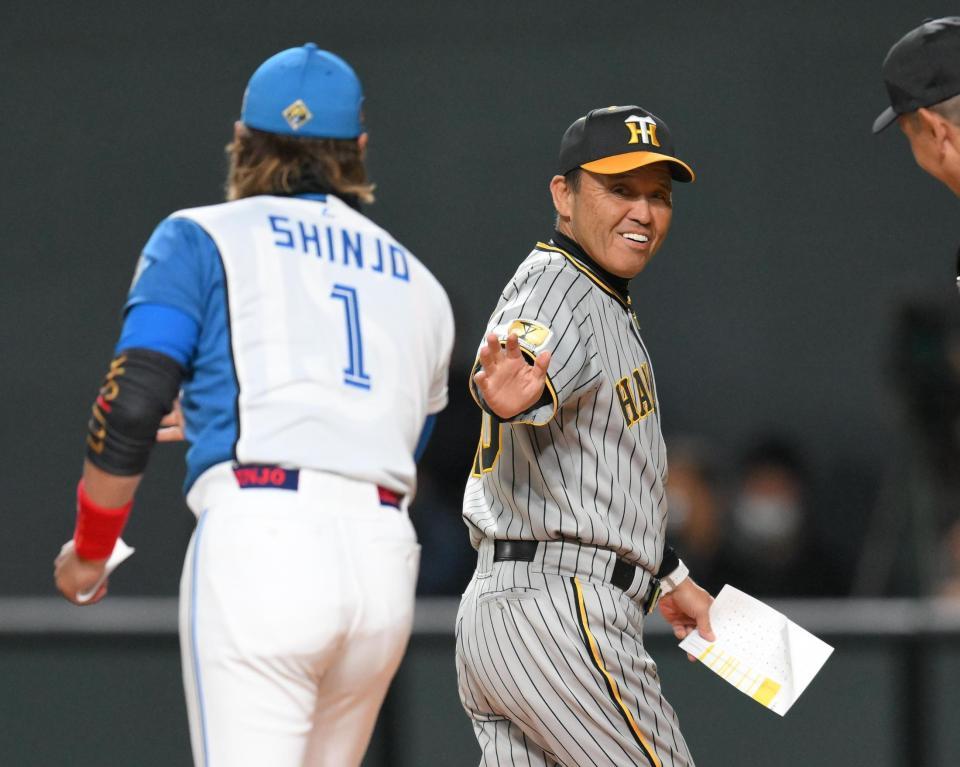 　試合前のメンバー確認を終えて新庄監督（左）に声をかける岡田監督（撮影・堀内翔）