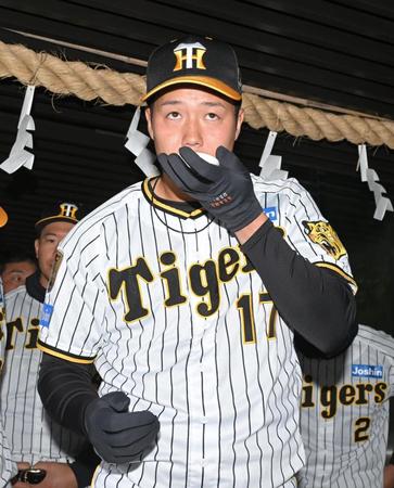 　御神酒を拝載する青柳（撮影・石井剣太郎）