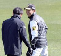 　馬場（左）からあいさつされ笑顔を見せる岡田監督（撮影・山口登）