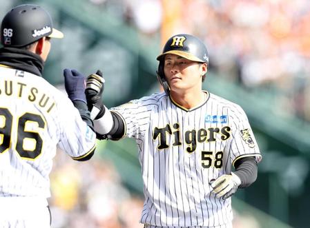 　６回、この日２本目の安打を放ち、筒井コーチ（左）とタッチを交わす前川（撮影・中田匡峻）