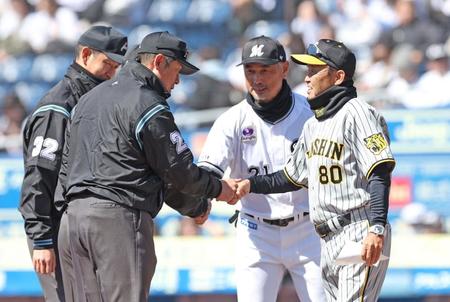 　吉井監督（右後方）とメンバー表交換を終え、審判団と握手を交わす岡田監督（撮影・中田匡峻）