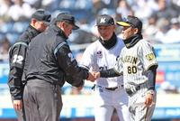 　吉井監督（右後方）とメンバー表交換を終え、審判団と握手を交わす岡田監督（撮影・中田匡峻）