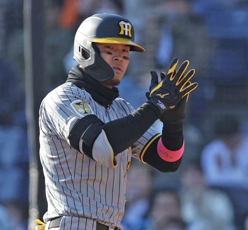 　９回、中前に２点適時打を放ち、手をたたく佐藤輝（撮影・中田匡峻）