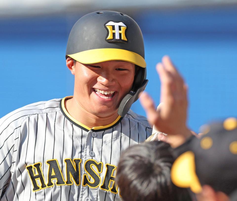 　８回、糸原の適時失策で生還した森下はナインと笑顔でタッチを交わす（撮影・中田匡峻）