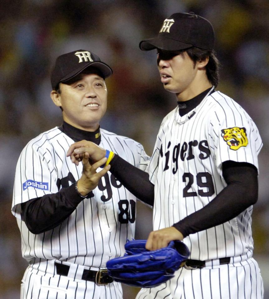 　完投勝利を挙げ岡田監督（左）に迎えられる井川＝２００６年９月２７日、甲子園