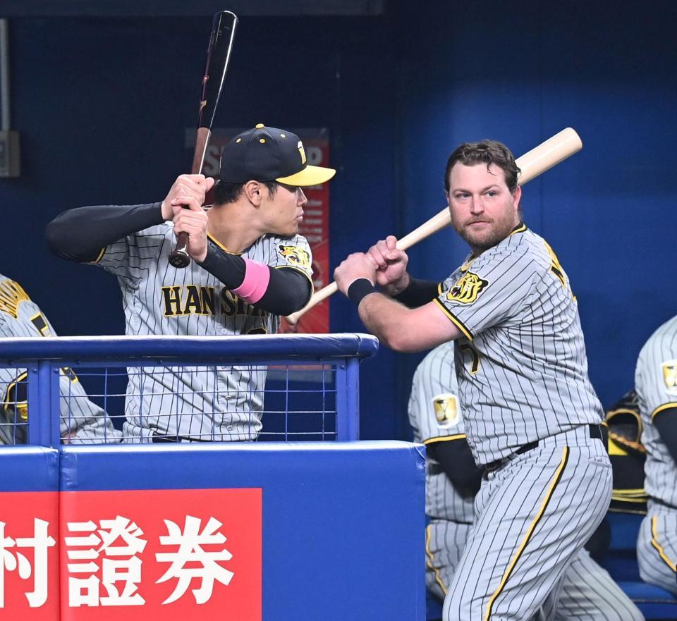 　ベンチでノイジー（右）から打撃のアドバイスを受ける佐藤輝（撮影・飯室逸平）