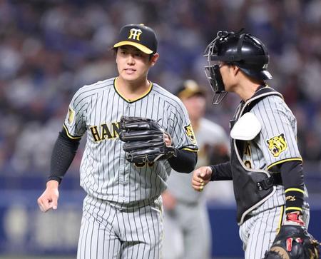 　８回に登板し、１イニングを無失点に抑えた石黒（左）は藤田とタッチを交わしベンチに向かう（撮影・中田匡峻）