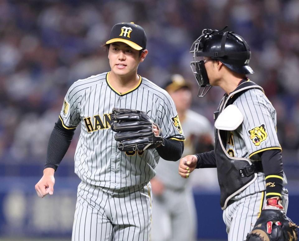 　８回に登板し、１イニングを無失点に抑えた石黒（左）は藤田とタッチを交わしベンチに向かう（撮影・中田匡峻）