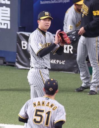 　３回、西川の二直を処理した中野（５１）をグラブをたたきながら迎える才木（撮影・中田匡峻）