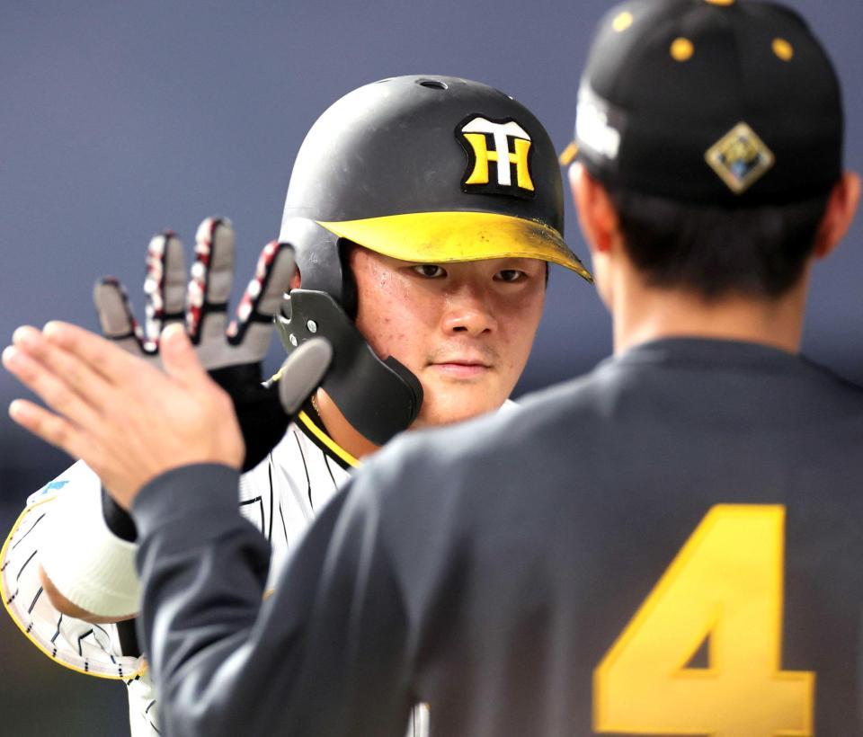 　４回、糸原の犠飛で生還しナインとタッチを交わす前川（撮影・田中太一）