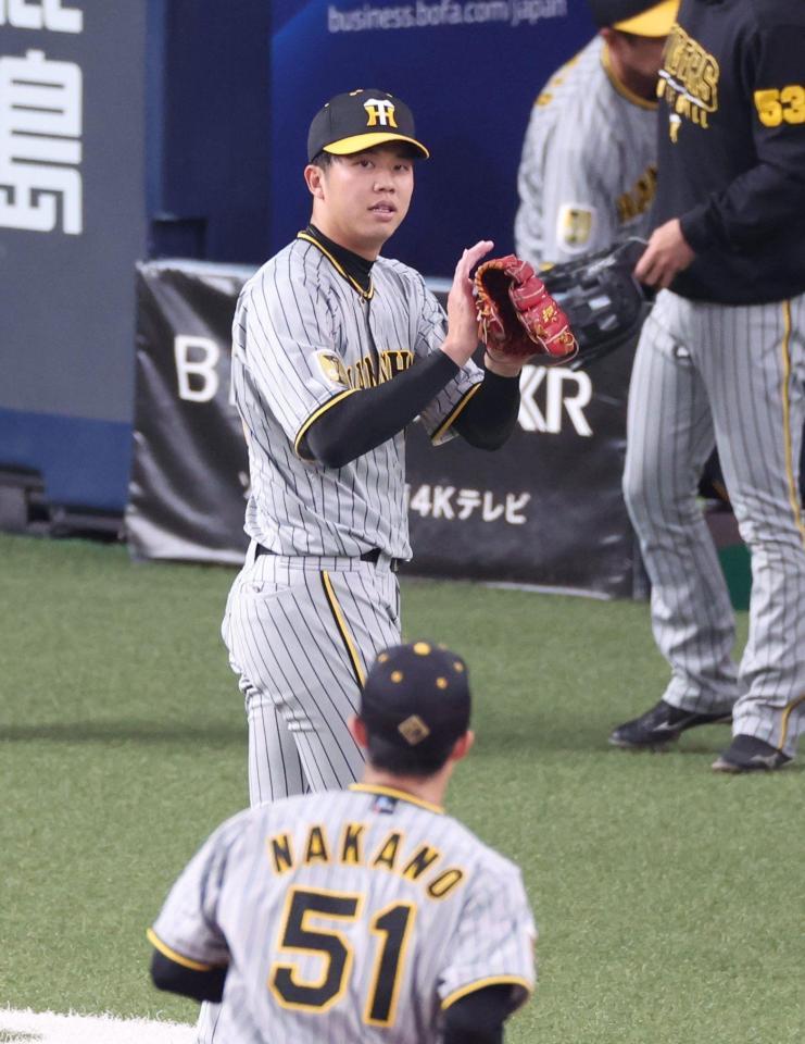 　３回、西川の二直を処理した中野（５１）をグラブをたたきながら迎える才木（撮影・中田匡峻）