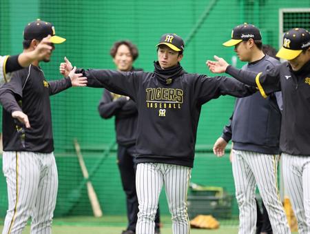 　ウオーミングアップをしながら談笑する近本（撮影・立川洋一郎）