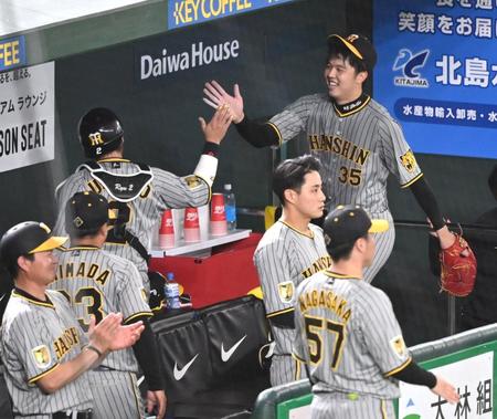 　４回のピンチを切り抜け、梅野（左）とタッチを交わす才木（撮影・棚橋慶太）