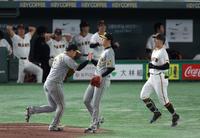 　６回、梶谷（右）を一ゴロに打ち取り、大山（左）とタッチを交わす才木（撮影・中田匡峻）