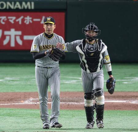 　最後を締めた岩崎（左）はグラブをたたく。右は梅野（撮影・中田匡峻）