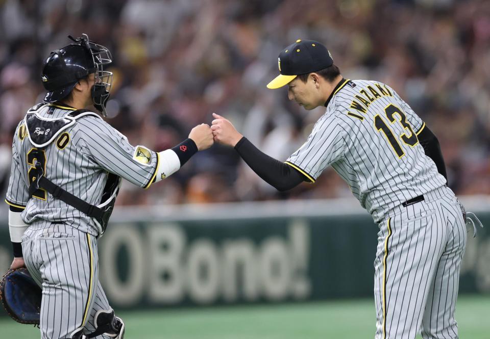 　最後を締め、梅野とタッチをかわす岩崎（撮影・金田祐二）