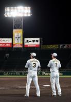 　ナイター練習でノックの打球を見上げる大山（左）と森下（撮影・山口登）