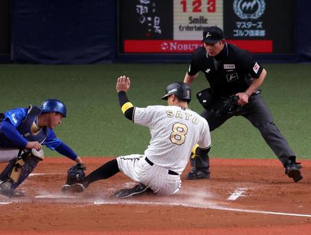 　４回、木浪の一塁ゴロで本塁を狙う佐藤輝。判定はアウトもリプレイ検証で判定が覆る（主審・真鍋）＝撮影・山口登