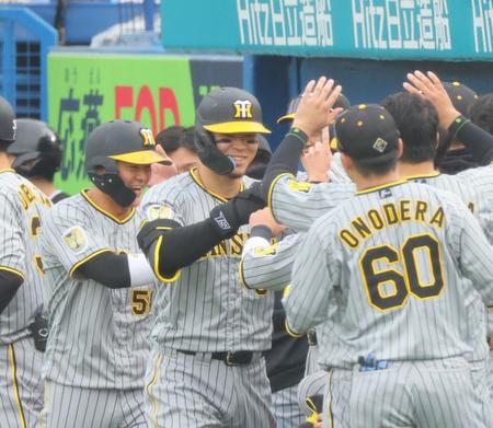 　７回、勝ち越し２ランを放ち、ナインの出迎えに笑顔で応える佐藤輝（撮影・吉澤敬太）