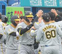 　７回、勝ち越し２ランを放ち、ナインの出迎えに笑顔で応える佐藤輝（撮影・吉澤敬太）