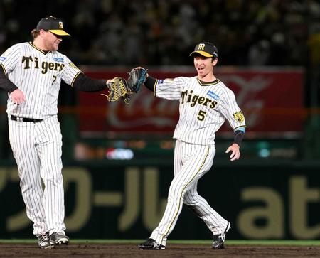 　広島に勝利し、ノイジー（左）と笑顔でタッチを交わす近本（撮影・中田匡峻）