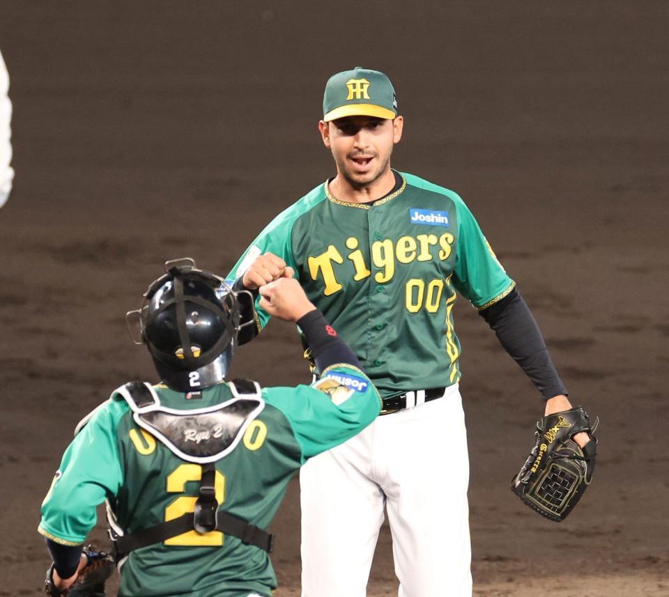 　試合を締めたゲラは梅野（手前）とタッチを交わす（撮影・中田匡峻）