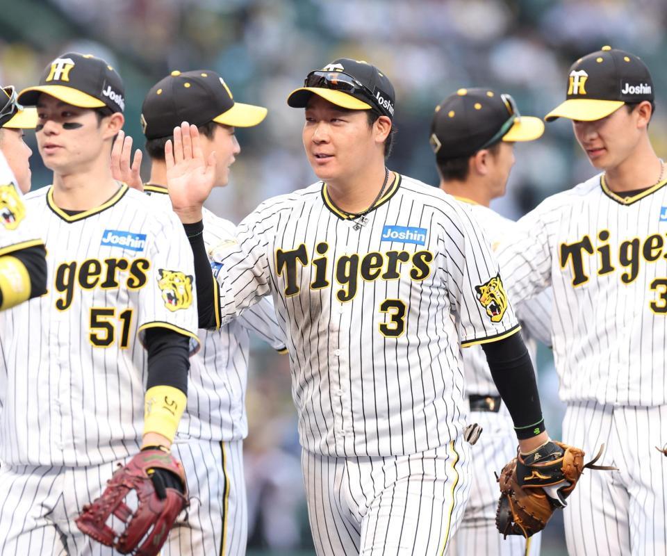 　中日に勝利し、ナインとタッチを交わす大山（撮影・中田匡峻）