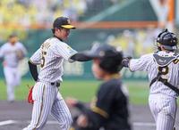 　１回を投げ終えて梅野（右）とタッチを交わして引き揚げる才木（撮影・立川洋一郎）