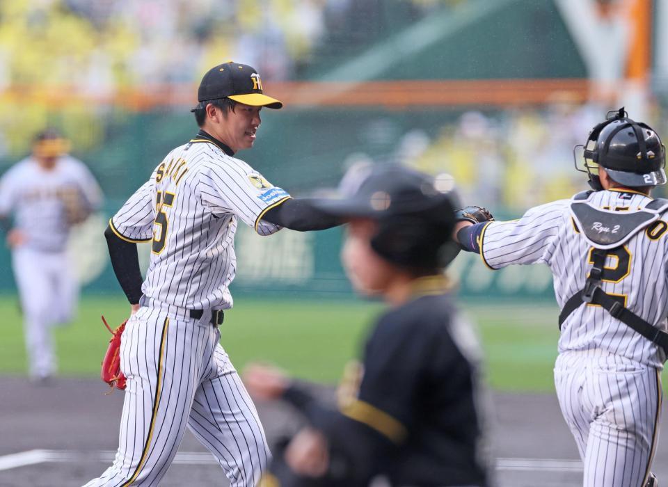 　１回を投げ終えて梅野（右）とタッチを交わして引き揚げる才木（撮影・立川洋一郎）