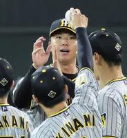 　完投勝利を挙げ木浪からウイニングボールを受け取る村上（撮影・立川洋一郎）