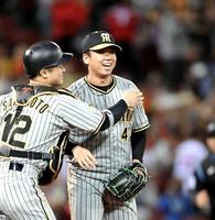 　完投勝利し、坂本（左）にねぎらわれる村上（撮影・市尻達拡）