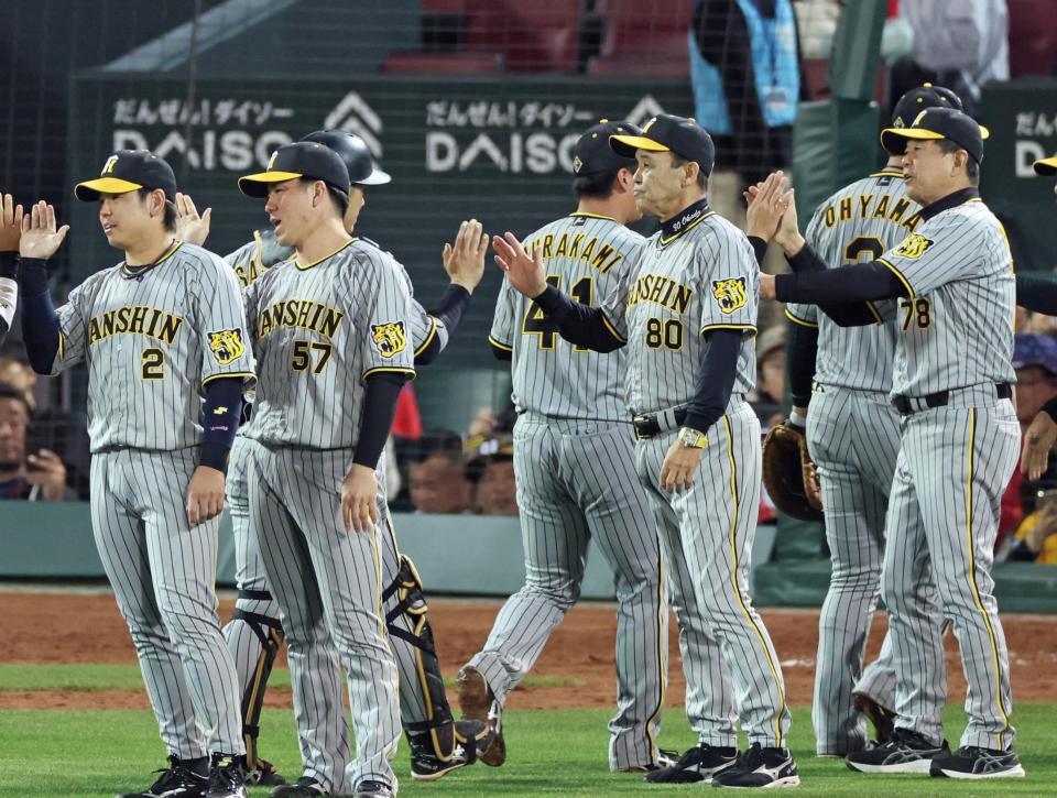 　ナインと勝利のタッチを交わす岡田監督（８０）＝撮影・立川洋一郎