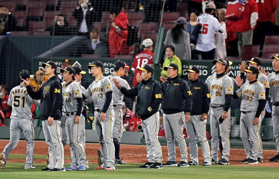 　引き分けで試合を終えナインとタッチを交わす岡田監督（中央）＝撮影・立川洋一郎）